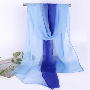 Detail of blue gradient silk scarf hanging on a metal rod with minimalist props