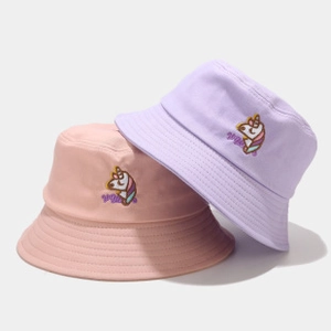 Dettaglio ravvicinato del ricamo a unicorno su cappelli a secchiello in rosa e viola