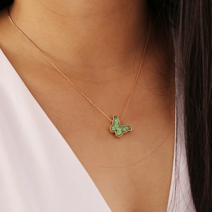 Elegante goldene Kette mit grünem Glitzer-Schmetterling Anhänger am Modell getragen