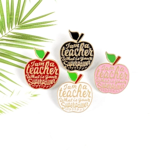 Set of four colorful apple teacher enamel pins with golden edges and slogan engraving