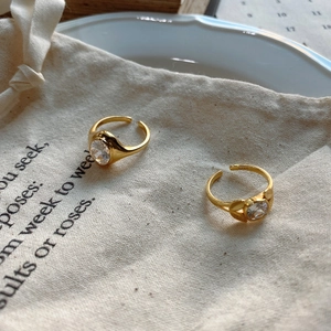 Macro shot of S925 sterling silver gold ring with round zircon on a linen bag