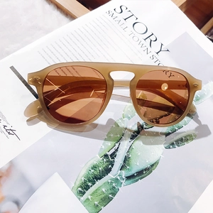 Close-up of retro tea-colored oversized sunglasses on a stylish magazine background