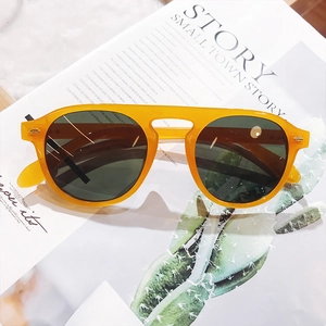 Detail of amber translucent frame sunglasses with dark lenses on a lifestyle magazine background