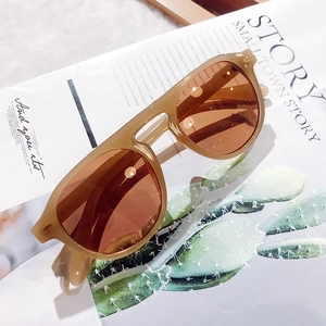 Detailed close-up of amber oversized sunglasses on a minimalist magazine background