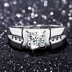 Macro shot of polished silver men's ring with square setting and brilliant round center diamond