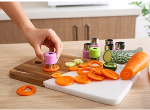 Action shot of stainless steel vegetable cutter mold pressing shapes on carrot slices