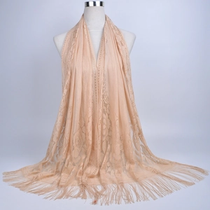 Close-up of light apricot lace scarf with intricate hollow pattern and fringe detail