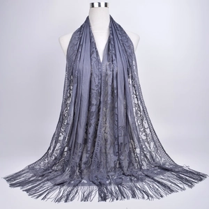 Macro shot of purple-gray lace scarf with hollow floral patterns and long fringe detail