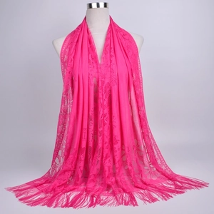 Detail of rose pink hollow lace scarf showing intricate floral patterns and long fringe trim