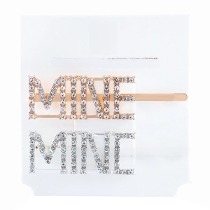 Close-up of gold and silver MINE letter hair clips with rhinestones on display card