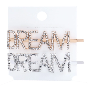 Close-up of gold and silver DREAM hair clips with rhinestones on a white display card