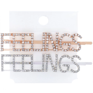 Close-up of FEELINGS letter hair clips with rhinestones in rose gold and silver finish