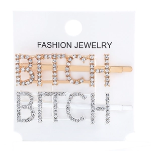 Detailed view of silver and gold rhinestone hair clips spelling BITCH on a white display card