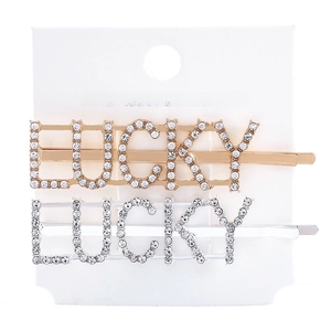 Detail of gold and silver LUCKY letter hair clips with shimmering crystal rhinestones