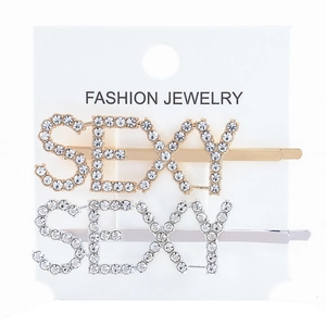 Close-up of gold and silver hair clips with sparkling rhinestones spelling SEXY on card