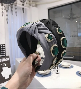 Close-up of emerald gemstones and rhinestones on baroque style knotted headbands