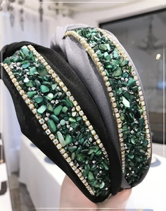 Macro detail of Baroque emerald crystals and rhinestones on knoted velvet headband