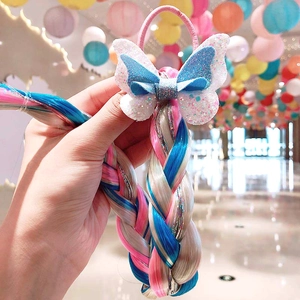 Close-up of glitter bow hair tie with pink and blue braided hair extensions for girls