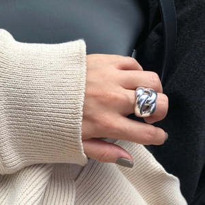 Close-up of 925 sterling silver chunky intertwined chain ring worn on finger