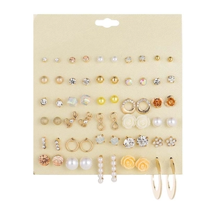 Close-up of 30 pairs of gold-tone stud earrings with pearls and crystals on card
