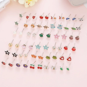 Macro view of a 36-pair set of floral and animal alloy stud earrings on a pink display