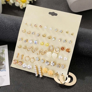 Detailed view of 30 pairs of stud earrings set with rhinestones and pearls on display card