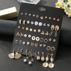 Detailed arrangement of 30 pairs assorted crystal and pearl stud earrings on black card