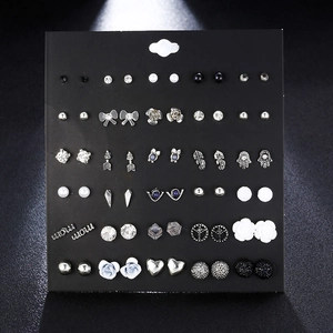 Detail view of various silver and black alloy stud earrings with rhinestones and pearls