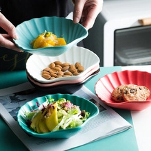 Detail of shell-shaped ceramic bowls in various colors used for salad and snacks