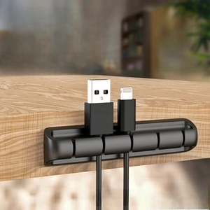 Macro shot of 5-slot silicone cable organizer with strong adhesive on desk edge