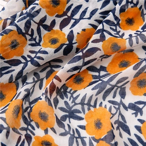 Detailed macro view of bohemian floral cotton-linen fabric with orange flowers and soft texture