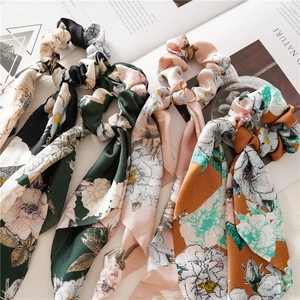 Floral silk ribbon scrunchies set in pink, green, black and orange on a magazine background