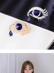 Detail view and model wearing an eye-shaped brooch with blue crystal teardrop charm