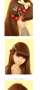 Detail view of cherry hair clip with polka dot and checkered bows on a child