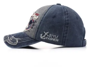 Close-up of distressed denim baseball cap with anchor embroidery and frayed edges