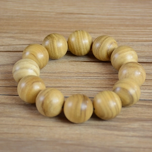 Natural Papua milky fragrance wood bead bracelet with 12 rounded beads on timber background