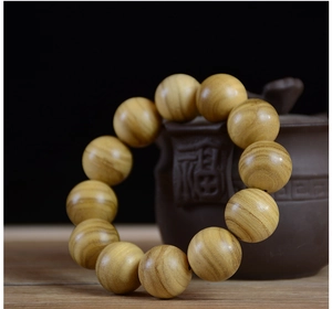 Close-up of 12 natural Papua wood beads bracelet with smooth texture and golden finish