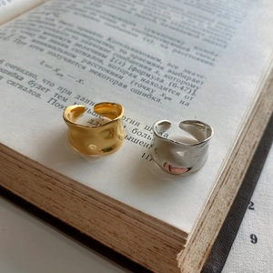 Macro detail of gold and silver irregular hammered wavy rings on a vintage book page