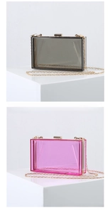 Detail view of transparent acrylic evening clutch with gold metal frame and chain strap