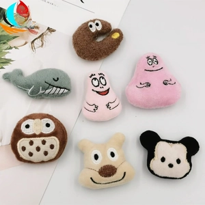 Detailed close-up of cute cartoon plush brooches featuring Barbapapa and Disney characters