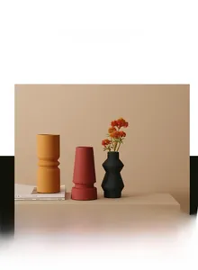 Detail van matte keramische vazen in Morandi-kleuren met texturen en droogbloemen