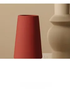 Detailopname van een Morandi steenrode keramische vaas met matte textuur en kegelvorm