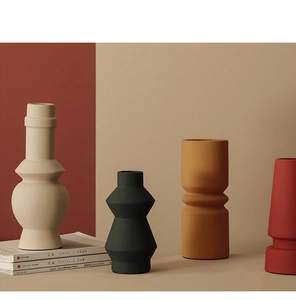 Detailopname van matte keramische vazen in geometrische vormen en Morandi-kleuren