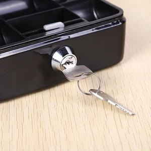 Mini black metal cash box with lock and two keys on a wooden surface for secure storage