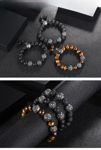 Detailed macro view of men's lava stone, tiger eye, and matte black beaded bracelets