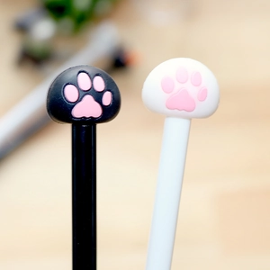 Close-up of creative cartoon cat paw toppers on black and white pens with pink details