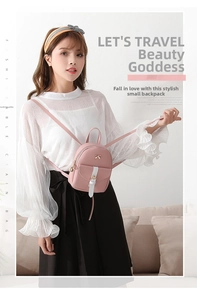 Pink mini PU leather backpack with a decorative metal bow and flap closure on a model