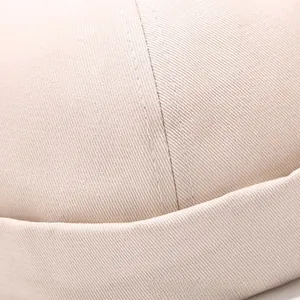 Detailed close-up of beige twill cotton fabric with professional double-stitched seams