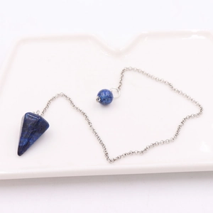 Macro detail of a conical blue stone pendant with gold flecks on a silver chain