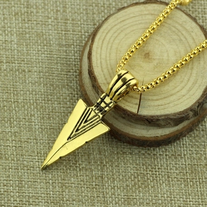Vintage golden metal arrowhead pendant necklace with bead chain on rustic wood background